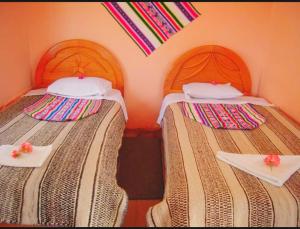 two beds sitting next to each other in a room at casa inti lodge in Isla Amantani