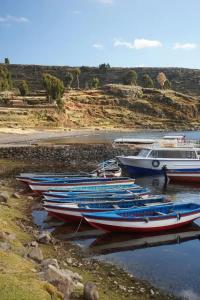 a group of boats sitting in the water at casa inti lodge in Isla Amantani