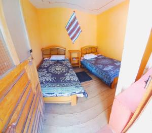 a small room with two beds in a house at casa inti lodge in Isla Amantani