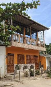 a house with wooden doors and a balcony at Casa Completa - Macondo Beach House in Rincón