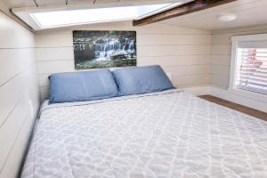 a bed in a small bedroom in a house at Tiny Home with Private Hot Tub, Zion Adventure Base in Apple Valley