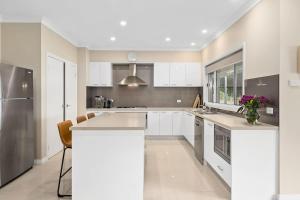 a kitchen with white cabinets and stainless steel appliances at Mole Hill Farmhouse in Lovedale