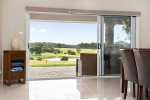 a room with a sliding glass door with a view of a field at Mole Hill Farmhouse in Lovedale
