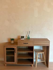 a wooden desk with a stool next to a wall at 시골마을 한옥독채 '가니재' in Ssangjŏng-ni