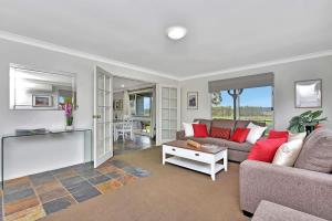 a living room with a couch and a table at Andres Farm Cottage in Broke