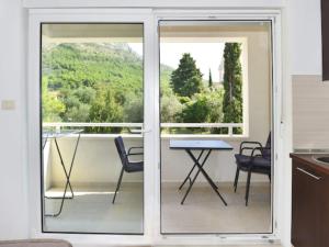 a kitchen with a balcony with a table and chairs at Apartments Despot Zaostrog RY in Zaostrog