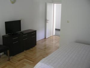 a bedroom with a bed and a dresser with a television at Apartments Despot Zaostrog RY in Zaostrog