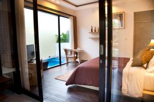 a bedroom with a bed and a sliding glass door at Muaya Villa in Jimbaran +126 photos