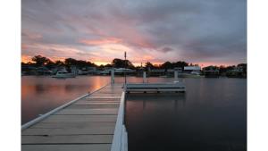 a dock on the water with a sunset in the background at Balmoral Jetty Estate in Balmoral
