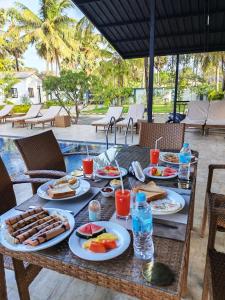 a table with plates of food and drinks on it at Aathi Resort in Trincomalee