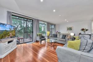 a living room with a tv and a couch at Villa 3br Chianti Villa located within Cypress Lakes Resort in Pokolbin