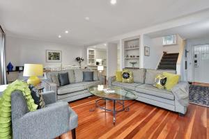 a living room with two couches and a table at Villa 3br Chianti Villa located within Cypress Lakes Resort in Pokolbin