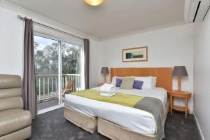 a bedroom with a large bed and a large window at Villa 3br Chianti Villa located within Cypress Lakes Resort in Pokolbin