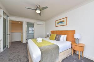 a bedroom with a large bed and a ceiling fan at Villa 3br Chianti Villa located within Cypress Lakes Resort in Pokolbin +22 photos