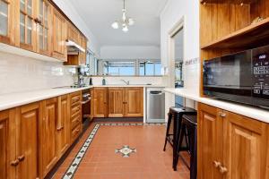 a large kitchen with wooden cabinets and a tile floor at Lakehouse on Alexander in Arcadia
