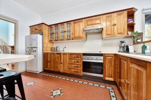a kitchen with wooden cabinets and stainless steel appliances at Lakehouse on Alexander in Arcadia +31 photos