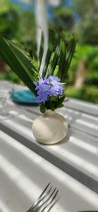 a vase with purple flowers in it on a table at Cottage Manua in Temae