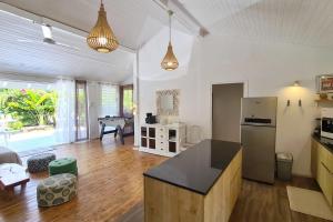 a kitchen and living room with a refrigerator and a table at Cottage Manua in Temae +52 photos