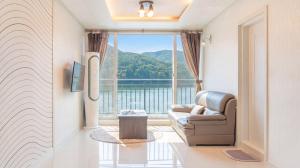 a living room with a couch and a large window at Gapyeong Rialto Pension in Gapyeong