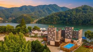 an aerial view of a resort with a river and mountains at Gapyeong Rialto Pension in Gapyeong