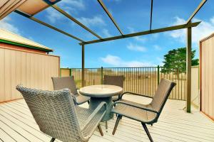 a patio with a table and chairs on a deck at King 2 - close proximity to Bimbadgen and Hope Estate concerts in Pokolbin