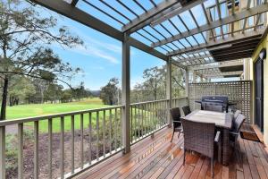 a patio with a table and chairs on a deck at Villa 3br Malbec Villa located within Cypress Lakes Resort in Pokolbin