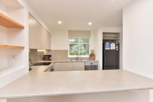 a kitchen with white counters and a black refrigerator at Villa 3br Malbec Villa located within Cypress Lakes Resort in Pokolbin +19 photos