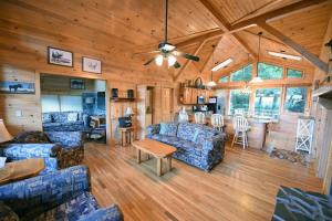 a living room with blue couches and a dining room at 6BR/5BA Retreat • Hot Tub • Game Room • Treehouse in Blue Ridge