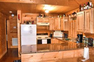 a kitchen with wooden cabinets and a white refrigerator at Trail`s End-Hot tub-wifi,-pets ok-Pool Table-Fireplace-Screened Porch-Activities in Mashburn Mill