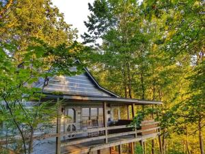 a house in the woods with a porch at Trail`s End-Hot tub-wifi,-pets ok-Pool Table-Fireplace-Screened Porch-Activities in Mashburn Mill