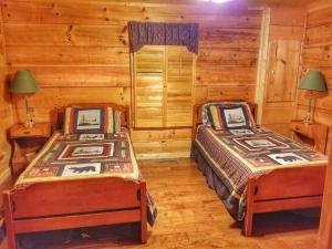a bedroom with two beds in a log cabin at Trail`s End-Hot tub-wifi,-pets ok-Pool Table-Fireplace-Screened Porch-Activities in Mashburn Mill