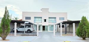 a white house with a truck parked in front of it at Ap Conforto no Centro de Sinop in Sinop