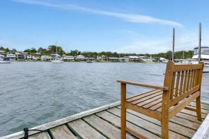 a wooden bench sitting on a dock near the water at Balmoral Waterfront Escape at Lake Macquarie in Balmoral