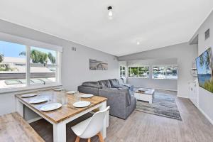 a living room with a table and a couch at Balmoral Waterfront Escape at Lake Macquarie in Balmoral +43 photos