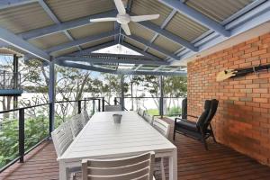 a white table and chairs on a deck with a ceiling at Wangi Dreaming in Wangi Wangi +19 photos