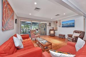 a living room with a red couch and chairs at Wangi Dreaming in Wangi Wangi