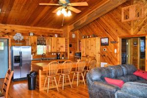 a living room with a couch and a kitchen at 2BR/1BA Cabin | Hot Tub | Ocoee River Area | Wifi in Copperhill