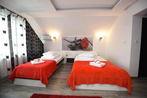 ハツェグにあるCasa Avyのベッドルーム1室(赤いシーツを使用したベッド2台付)