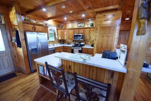 a kitchen with a large island in a wooden cabin at 4BR/3BA | Hot Tub | Pool Table | Views | Pets ok in Blue Ridge