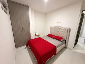 a small bedroom with a bed with a red blanket at Alojamiento Rozo in Girón