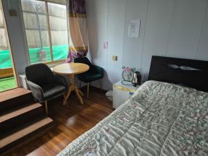 a bedroom with a bed and a table and chairs at Gana's Guest House and Tours in Ulaanbaatar