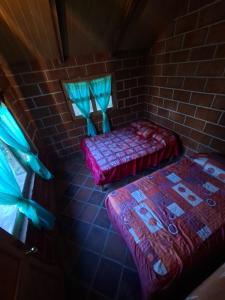a room with two beds and a brick wall at Rancho buena vista in Mineral del Chico