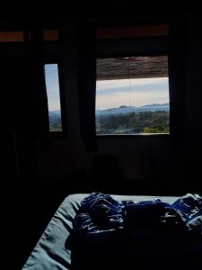 a bedroom with a bed and two windows with a view at Ruteng Glamping & Campsite in Ruteng
