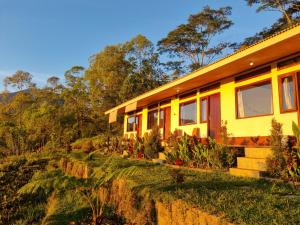 a yellow house on top of a hill at Ruteng Glamping & Campsite in Ruteng