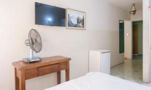 a bedroom with a bed and a table with a fan at Hotel Marsal in Antofagasta