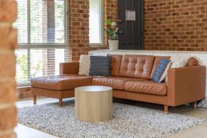 a brown leather couch sitting in a living room at Tulloch Estate in Tuncurry