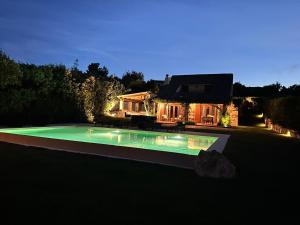 a swimming pool in front of a house at night at Domus de pedra in Marina di Portisco