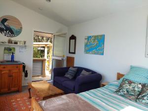 a living room with a bed and a couch at Endeavour View Eco Cabin in Endeavour Inlet