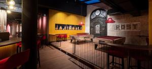 a restaurant with a row of tables and red chairs at Hotel Postgalerie Speyer in Speyer