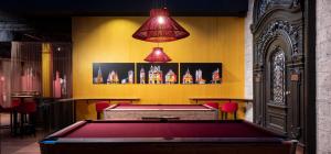 a pool table in a bar with two lights above it at Hotel Postgalerie Speyer in Speyer